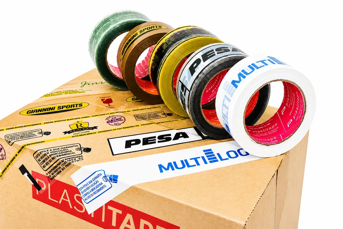 Fitas personalizadas em várias cores aplicadas em caixa kraft — verde, marrom, amarelo, preto e branco